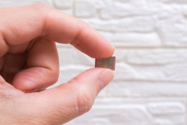 Cep telefonu iletişimi için bir mikro sim kartı tutan parmaklar