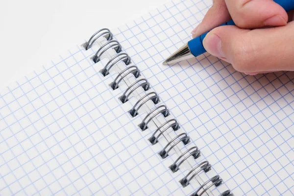 Skriva anteckningar eller planera ett schema på tom spiral anteckningsbok, hand med hjälp av en penna på en rutig tomt papper, kopiera utrymme — Stockfoto