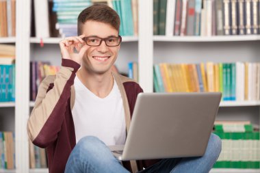bir laptop holding neşeli genç adam