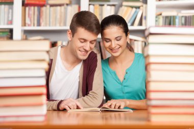 neşeli genç erkek ve kadın masanda Kütüphane Danışma