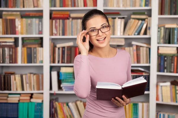 Fröhliche junge Frau mit Buch in der Hand — Stockfoto