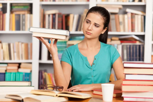 Mujer joven deprimida sentada en el escritorio de la biblioteca — Foto de Stock