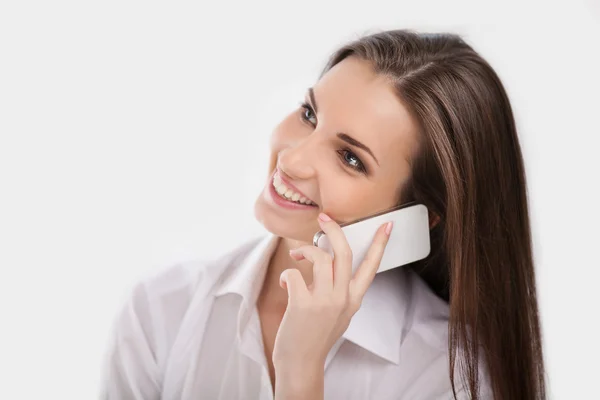 Mujer joven en camisa blanca hablando en el teléfono móvil — Foto de Stock