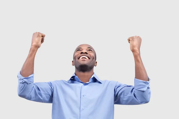 Young black man smiling and keeping raised arms — Stock Photo, Image