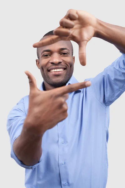 Afrikanischer Mann, der sich auf dich konzentriert und lächelt — Stockfoto