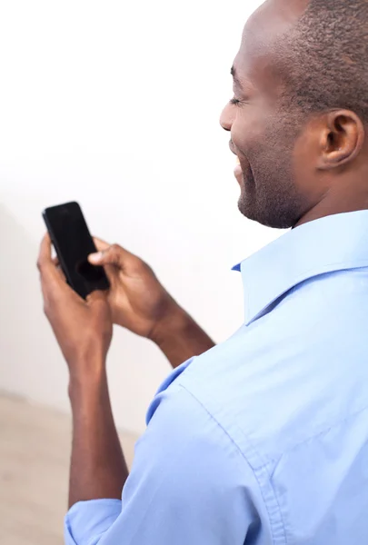 Zwarte man te typen op de mobiele telefoon — Stockfoto