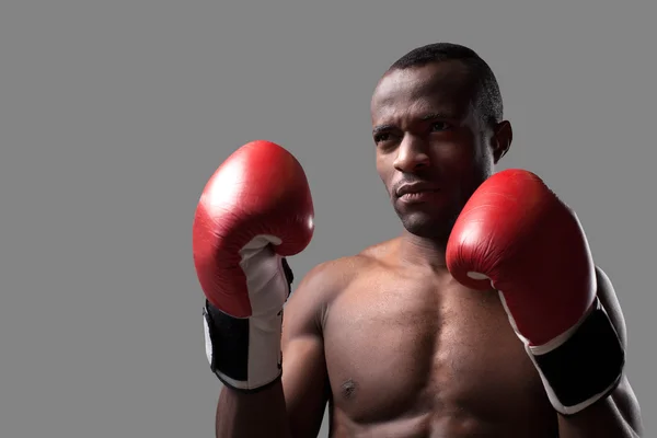 African boxer in boxing gloves looking away — Stock Photo, Image