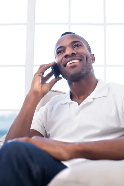 Africký muž mluví na mobilním telefonu a usmívá se — Stock fotografie