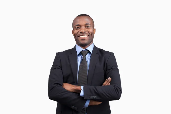 Africano manteniendo los brazos cruzados y sonriendo — Foto de Stock