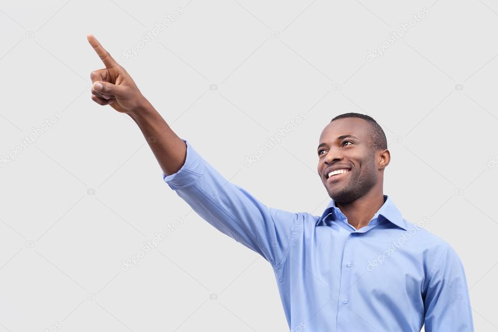 Black man pointing away and smiling
