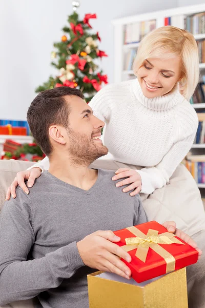 Mann hält eine Geschenkbox, während ihre Freundin hinter ihm steht — Stockfoto