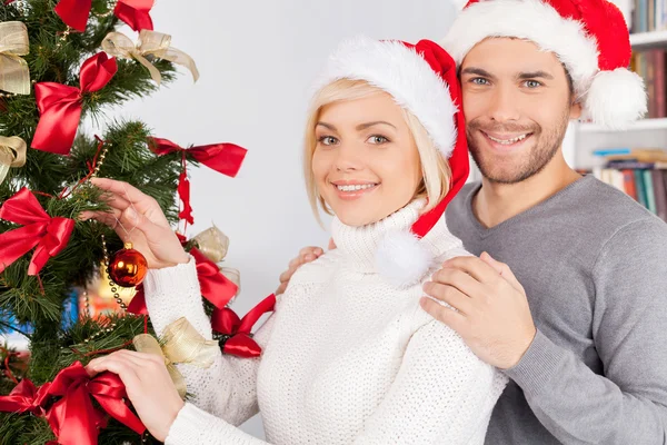 Pareja decorando un árbol de Navidad juntos — Foto de Stock