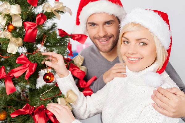 Paar schmückt gemeinsam einen Weihnachtsbaum — Stockfoto