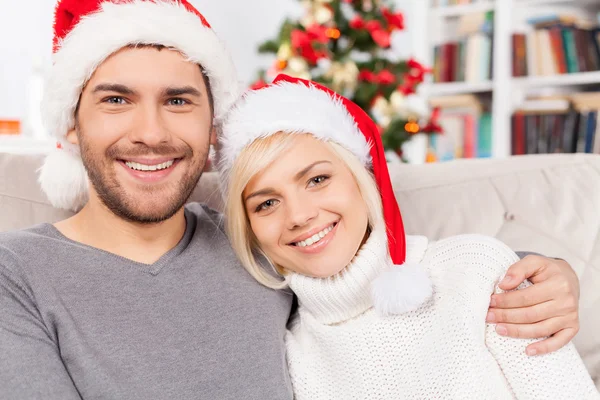 Couple sitting on the couch and smiling at camera Royalty Free Stock Images