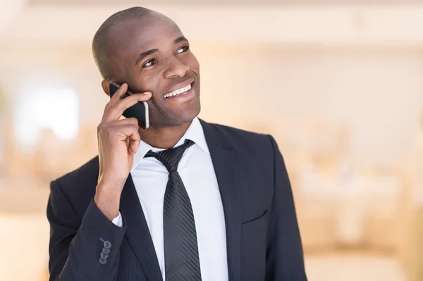 Cheerful young African man in formalwear talking on the mobile phone — Stock Photo, Image
