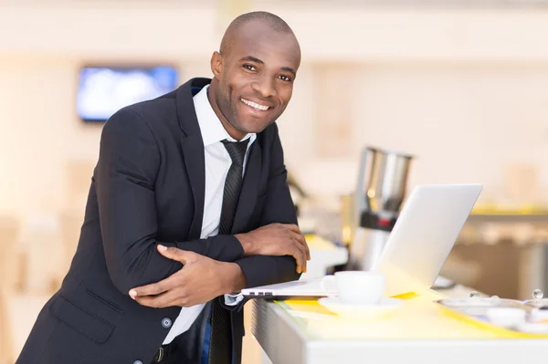 Man in formalwear met behulp van zijn laptop terwijl leunend op bar — Stockfoto