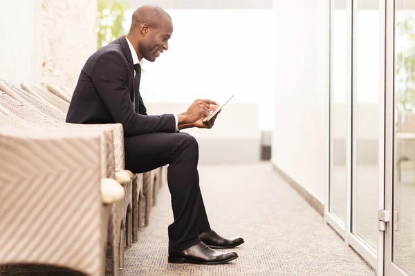 Businessman working on digital tablet and smiling