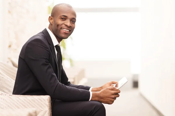 Homme d'affaires travaillant sur tablette numérique et souriant — Photo