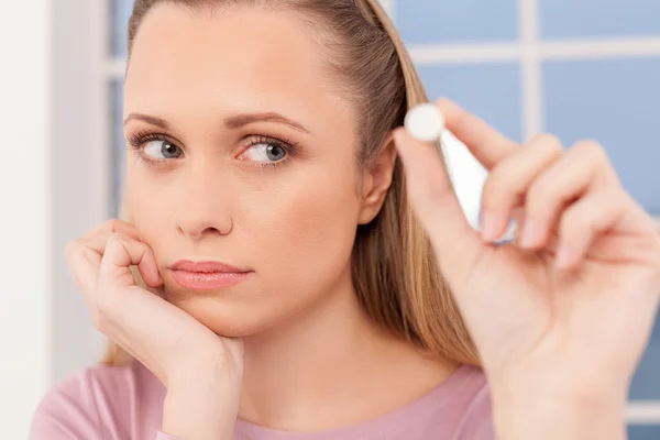 Depressed young woman holding a pill — Stock Photo, Image