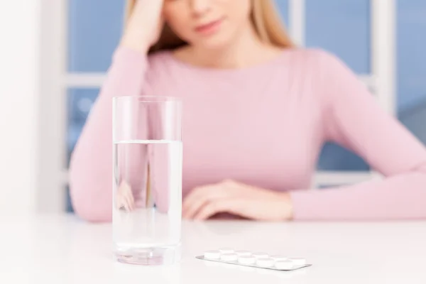 Depressed young woman holding head in hand — Stock Photo, Image