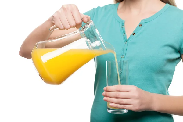 Woman pouring juice into glass — Stock Photo, Image
