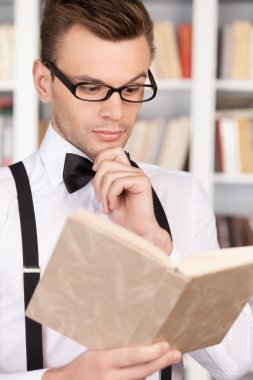 gömlek ve papyon kitap okuyarak kendine güvenen genç adam