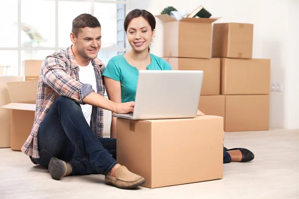 Couple sitting on the floor and working on laptop — Stock Photo, Image