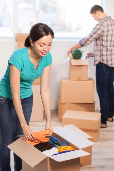 Young woman unpacking a carton box — Stock Photo, Image