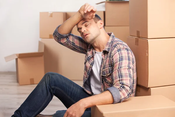 Tired young man sitting on the floor — Stock Photo, Image