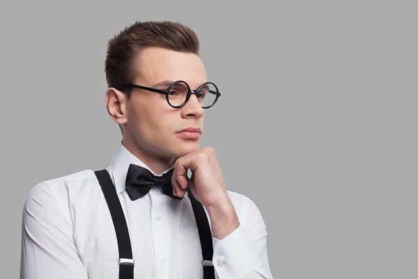 Thoughtful young nerd man holding hand on chin — Stock Photo, Image