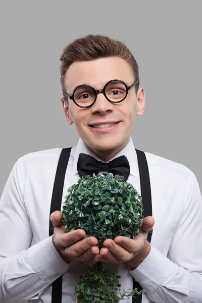 Веселий молодий чоловік тримає рослину — стокове фото