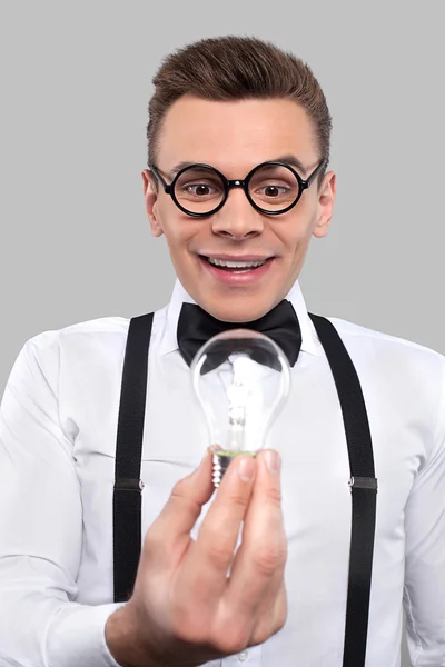 Surprised young man holding a light bulb — Stock Photo, Image