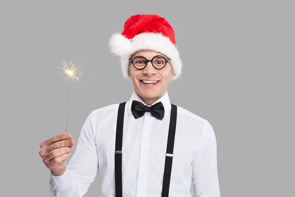 Young nerd man in bow tie and suspenders holding a sparkler — Stock Photo, Image