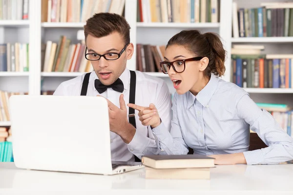 Sorpresa giovane coppia nerd in occhiali guardando monitor del computer — Foto Stock