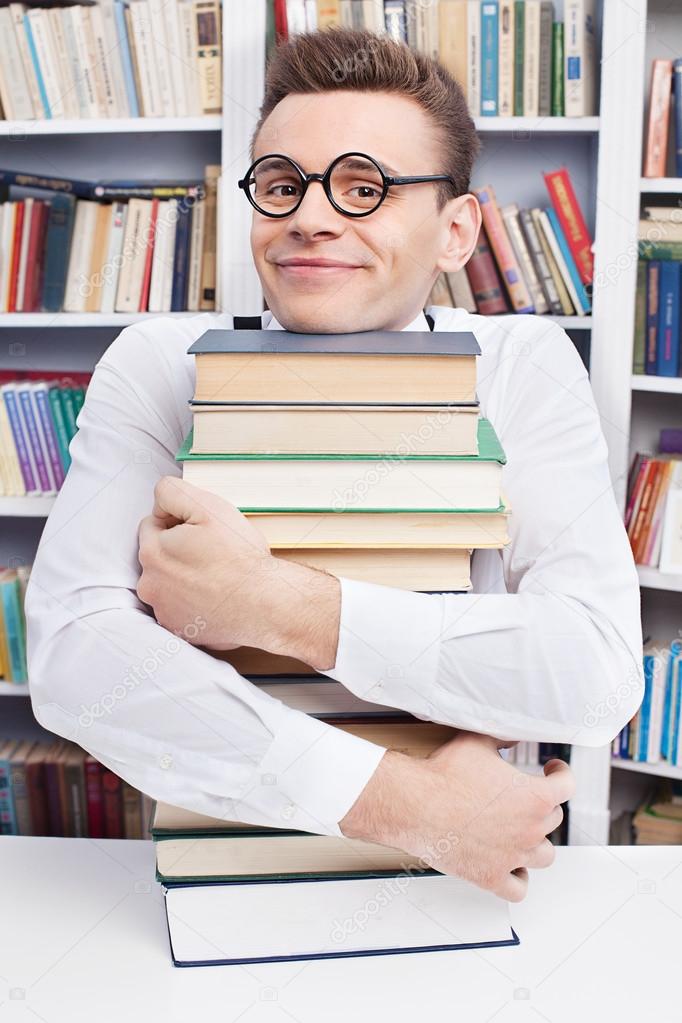 Nerd man hugging a book stack