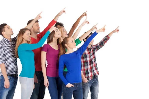 Young multi-ethnic people standing pointing away — Stock Photo, Image