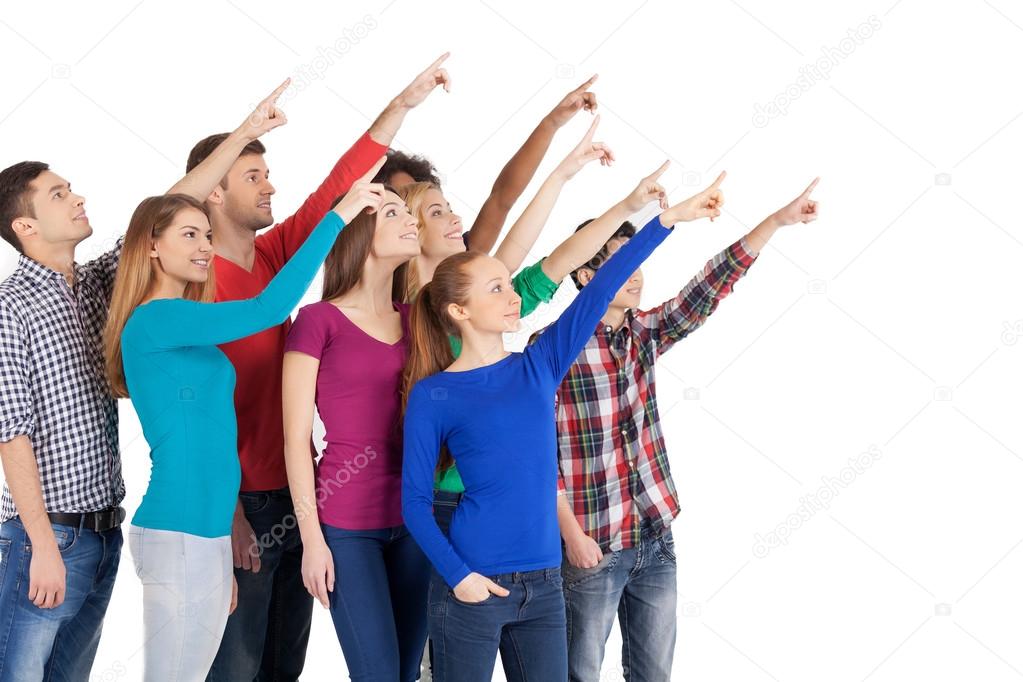 Young multi-ethnic people standing pointing away