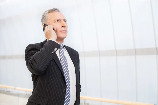 Confident senior man in formalwear talking on the mobile phone — Stock Photo, Image