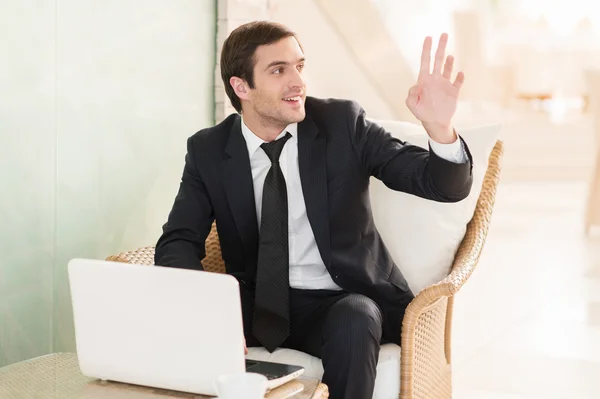 Empresário usando seu laptop e gesticulando no restaurante — Fotografia de Stock