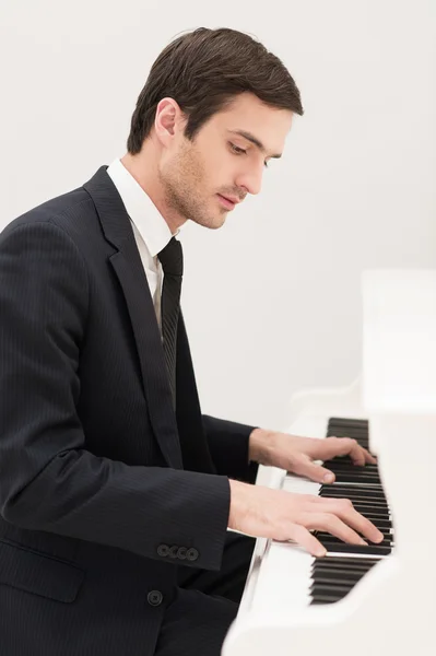 Ung man i formalwear spela piano — Stockfoto