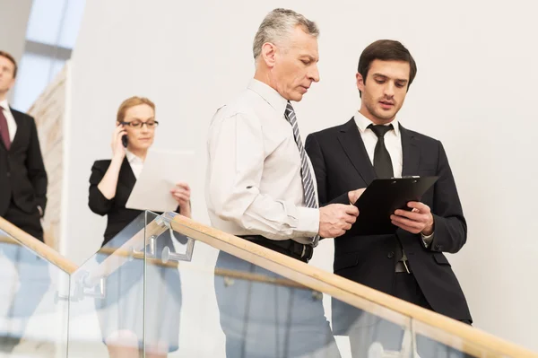 Personas en ropa formal bajando por escalera — Foto de Stock