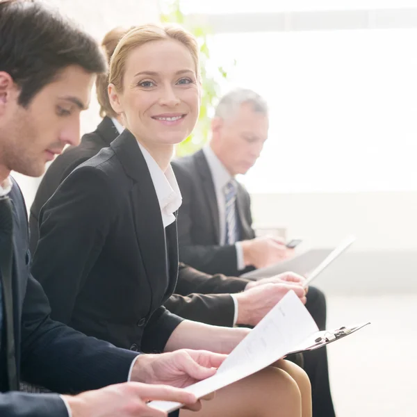 Four people in formalwear waiting in line — Stock Photo, Image