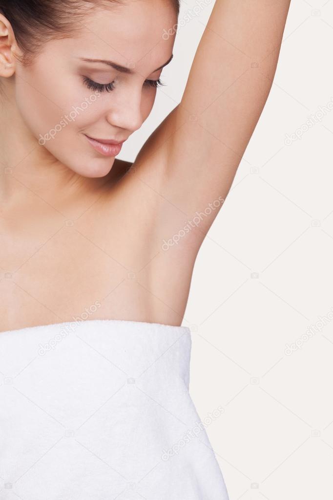 Woman wrapped in towel keeping arm raised