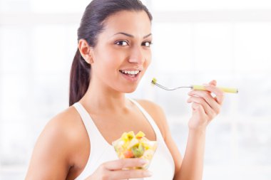 Hintli kadın bir meyve salatası yemek