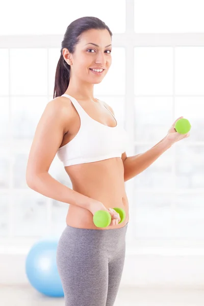 Attractive young Indian woman holding dumbbells — Stock Photo, Image