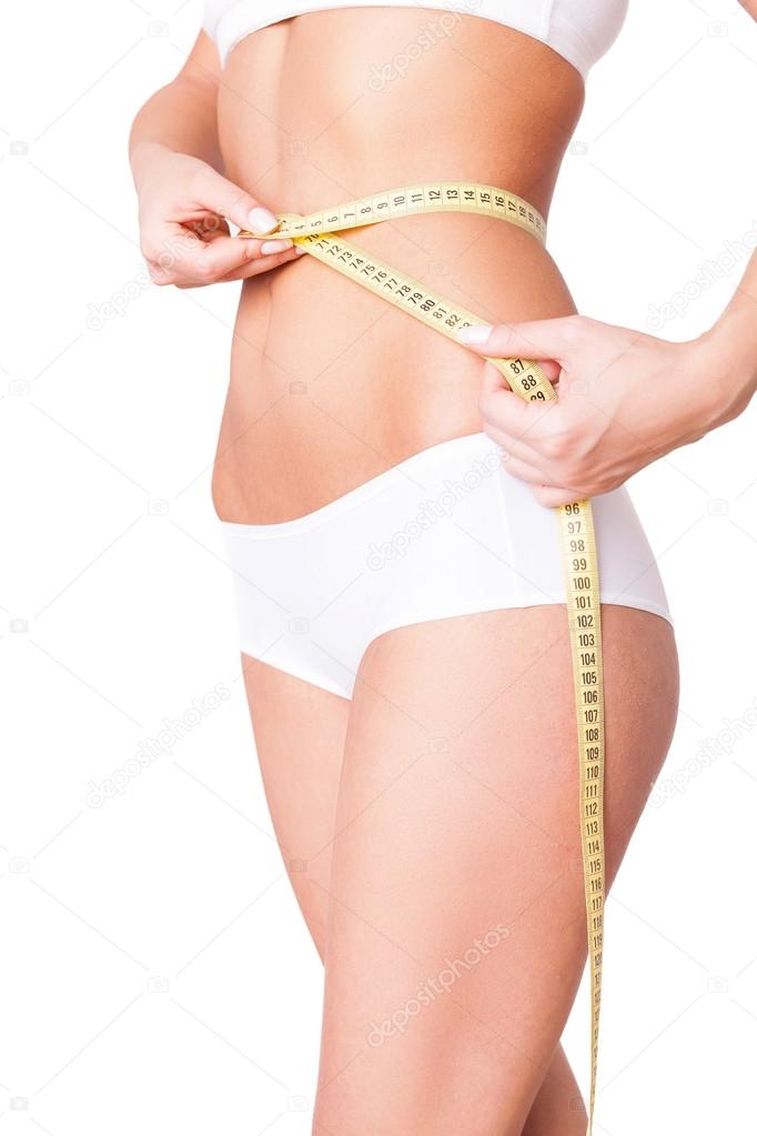 Woman measuring toned waist.