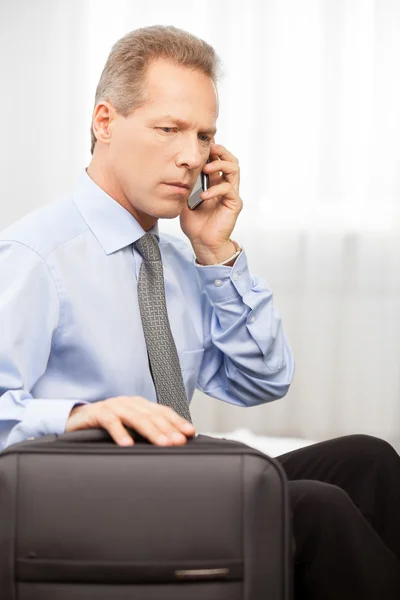 Man talking on the phone while sitting on bed — Stock Photo, Image