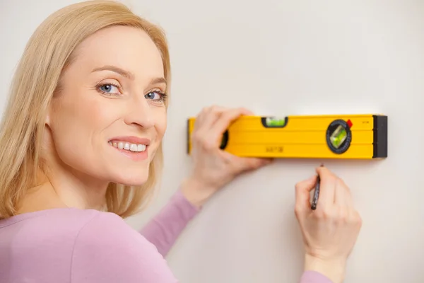 Mujer tomando medidas de la pared — Foto de Stock