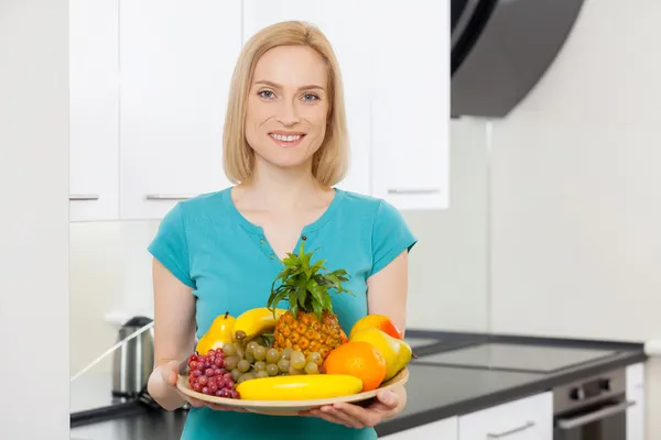 Женщина держит тарелку с фруктами — стоковое фото