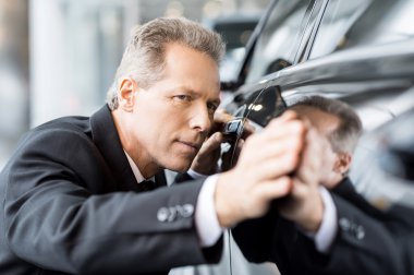 Businessman examining car